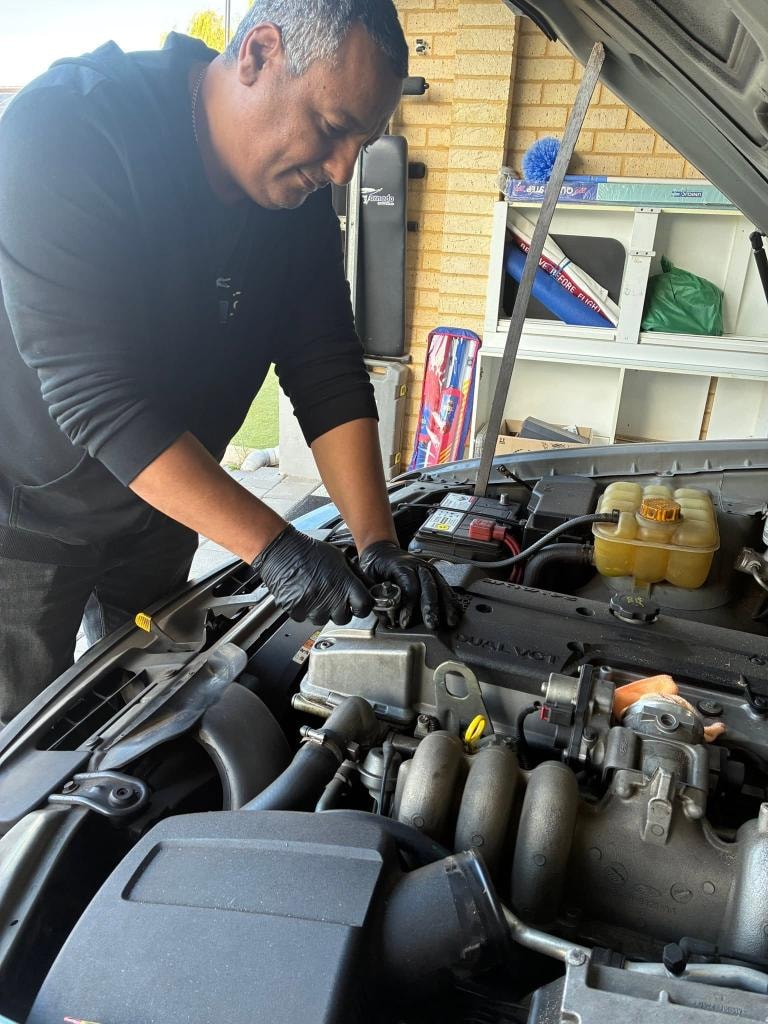 Mobile mechanic inspecting suspension and wheel arch on a Perth driveway